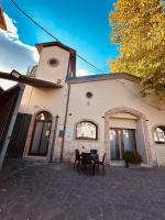een gebouw met een tafel en stoelen ervoor bij B&B Hora Sesta in Melfi