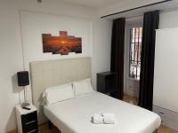 A bed or beds in a room at Apartamentos Day Madrid SANTO DOMINGO Centro Gran Via Sol Malasaña