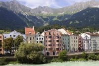 a group of buildings next to a river and mountains at Hotel Mondschein in Innsbruck