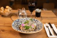 un plato de pasta en una mesa con una copa de vino en L'Harmony, en Saint-Arnoult-en-Yvelines