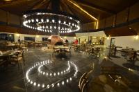 een restaurant met tafels en stoelen en een grote kroonluchter bij Kayı Resort Hotel in Sarıkamıs