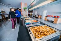 een vrouw die door een rij met etenswaren loopt bij Kayı Resort Hotel in Sarıkamıs