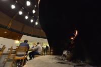 een groep mensen die rond een vuur in een tent zitten bij Kayı Resort Hotel in Sarıkamıs