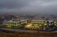 a building with green lights in a city at night at Ewaa Express Hotel - Abha in Abha
