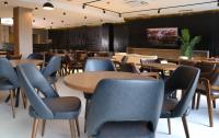 Un comedor con mesas y sillas y un televisor. en Keta Hotel & Spa - Mavrovo, en Mavrovo