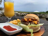 a sandwich and chips and a glass of orange juice at LOGINNtarassoログインタラソ沖永良部島 in Wadomari