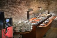 a buffet line with cups and plates of food at Wilson Palace by LOFT in Bratislava