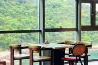 uma mesa e cadeiras em uma sala com uma grande janela em 阿卡那拉橘子海亲子民宿 em Dapengcheng