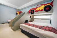 a bedroom with a bed with a cartoon car on the wall at Yellow Kite Hostel in Tainan