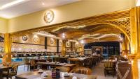 a dining room with wooden tables and chairs at Grand Sunshine Resort & Convention in Bandung