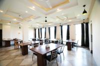 Un restaurante con mesas y sillas de madera y ventanas. en Hotel The Royal Palace, en Ahār