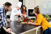 a group of people standing in a kitchen preparing food at Exceptionnel duplex vue mer à 3 mins de la plage in Grand Baie