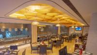 Un restaurante con mesas y sillas y un bar. en Radisson Blu Pune Hinjawadi, en Pune