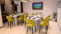 Un comedor con mesas y sillas amarillas. en Radisson Blu Pune Hinjawadi, en Pune