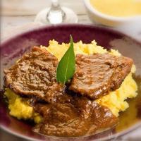 a plate of food with meat and mashed potatoes at B & B La Mela in Darfo