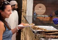 una mujer está sosteniendo un plato de comida en Banyan Luxury rum Camp, en Wadi Rum