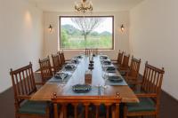 uma sala de jantar com uma mesa longa com cadeiras e uma janela em 成都传家合院（花舞人间店） em Xinjin