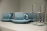 a table with cups and plates and a glass at Flat Casa Mauá in Rio de Janeiro