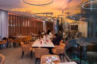 um restaurante com mesas e pessoas sentadas a eles em Grand Hotel&Casino Vía Dorada em Pachuca de Soto