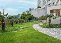 un jardín con palmeras y una pasarela en Geoje Hound Hotel & Spa, en Geoje