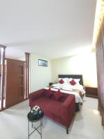 Un dormitorio con una cama y un sofá rojo. en Grand Mahoni Hotel, en Banda Aceh