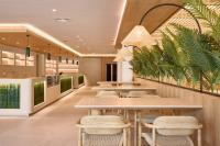 Un restaurante con mesas, sillas y plantas. en Calderona Wellness, en Bétera