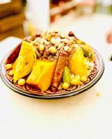 a plate of food with fruit and vegetables on a table at Riad Dar Karma in Marrakech