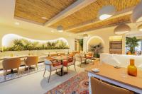 a restaurant with wooden ceilings and tables and chairs at Holiday Inn Dubai Village Circle by IHG in Dubai
