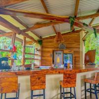 Un bar en una cabaña con paredes y sillas de madera en Cocobolo Beach Boutique Hotel, en San Juanillo