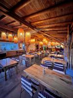 Un restaurante con mesas y sillas de madera y luces. en Hotel Campestre LA ALDEA, en Montenegro