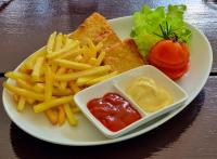 a plate of food with french fries and a tomato at Stellars Samed Resort in Ko Samed
