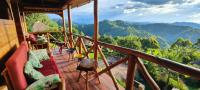 un balcón de una casa con vistas a las montañas en Agandi Uganda Eco-lodges, en Parque Nacional de la Selva Impenetrable de Bwindi