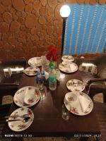 une table avec des assiettes et des fleurs au-dessus dans l'établissement Thrill Venture Manali Stays End to End Himachal Experience, Explore at your Pace! A true Hidden Gem, à Manali