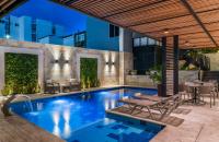 Una piscina con una mesa y sillas al lado de un edificio. en Hotel Elite, en Barrancabermeja