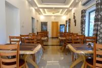Bonobitaan Hotel & Restaurant في Srī Niketan: غرفة طعام مع طاولات وكراسي خشبية