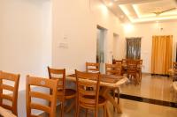 Bonobitaan Hotel & Restaurant في Srī Niketan: غرفة طعام مع طاولة وكراسي خشبية