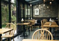 Un restaurante vacío con mesas y sillas de madera. en Slow Tatry Boutique Resort&SPA, en Zakopane