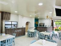 a restaurant with tables and chairs and a kitchen at Hotel & Villas Huetares in Playa Hermosa