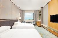揚州市にあるCourtyard by Marriott Yangzhouの病室にはベッド3台とテレビが備わります。