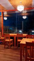 a restaurant with wooden tables and chairs and lights at Lhohi White Sand in Manadhoo