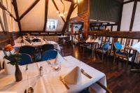 a restaurant with white tables and blue chairs at Gasthaus Fiester Hannes in Burbach