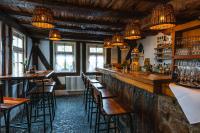 a bar with wooden tables and chairs and lights at Gasthaus Fiester Hannes in Burbach