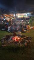 un grupo de personas sentadas alrededor de una fogata por la noche en Sunny Eco Lodge, en Cát Tiên