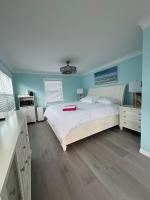 Un dormitorio con una cama blanca y paredes azules. en Flamingo Inn, en Fort Myers Beach