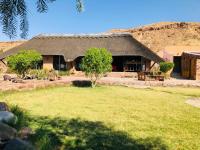 a house with a grass yard in front of it at Hais Ra Tented Campsite in Khorixas