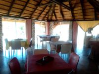 a dining room with tables and chairs and windows at Hais Ra Tented Campsite in Khorixas