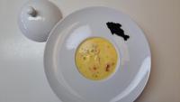 a white plate with a bowl of soup on a table at Évika boutique hotel in Eskilsby