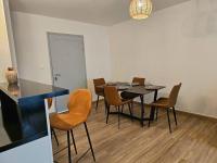 a dining room with a black table and chairs at T2 cosy avec place de parking in Mamoudzou