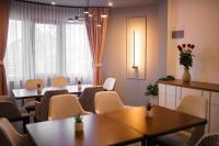 una sala de espera con mesas y sillas y una ventana en Vila Carol, en Alba Iulia