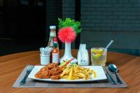 un plato de comida con pollo y papas fritas en una mesa en Heri Heights Hotel Apartments, SureStay Collection by Best Western, en Nairobi